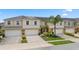 Beige two-story townhome featuring a well-maintained front yard, a driveway, and a one-car garage at 3018 Bargate St, Orlando, FL 32824