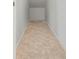 Narrow hallway with beige tiling, white walls, and white trim along the base of the walls at 3018 Bargate St, Orlando, FL 32824
