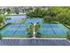 Aerial view of tennis and basketball courts surrounded by lush landscaping and a pond at 3018 Bargate St, Orlando, FL 32824