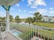 Scenic balcony view overlooking a tranquil pond, swaying palm trees, and community at 3020 Parrot Head Pl, Kissimmee, FL 34747