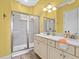 Bright bathroom featuring a double vanity, marble countertops, and a glass-enclosed walk-in shower at 3020 Parrot Head Pl, Kissimmee, FL 34747