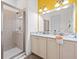 Bright bathroom featuring a double vanity, marble countertops, and a glass-enclosed walk-in shower at 3020 Parrot Head Pl, Kissimmee, FL 34747