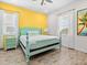 Charming bedroom with bright yellow wall with complementary light-blue bed frame and wood plank flooring for a cozy vibe at 3020 Parrot Head Pl, Kissimmee, FL 34747