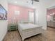 Bedroom featuring a comfortable bed, a pink accent wall, and an en suite bathroom at 3020 Parrot Head Pl, Kissimmee, FL 34747