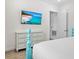 Bright bedroom displaying a mounted flat screen television and a turquoise decorative bed frame at 3020 Parrot Head Pl, Kissimmee, FL 34747