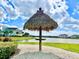 Community grounds feature thatched shade structure, lake views and garden areas at 3020 Parrot Head Pl, Kissimmee, FL 34747