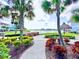 Scenic view of a community with colorful buildings, lush landscaping, and a serene lake at 3020 Parrot Head Pl, Kissimmee, FL 34747