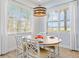 Inviting dining area with natural light with views, complemented by chic curtains and an elegant pendant lighting fixture at 3020 Parrot Head Pl, Kissimmee, FL 34747