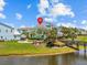 A home with lake view, landscaping, and a quaint bridge leading to property at 3020 Parrot Head Pl, Kissimmee, FL 34747