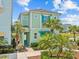 Charming two-story home with light green exterior and well-manicured landscaping, including mature palm trees at 3020 Parrot Head Pl, Kissimmee, FL 34747