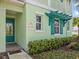 Charming home exterior featuring a colorful front door and lush landscaping at 3020 Parrot Head Pl, Kissimmee, FL 34747