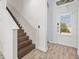 Welcoming foyer with staircase, tile flooring, and a charming entryway door that enhances the home's appeal at 3020 Parrot Head Pl, Kissimmee, FL 34747