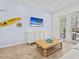 Bright living room featuring patio access, a decorative coffee table, and coastal-themed wall art at 3020 Parrot Head Pl, Kissimmee, FL 34747