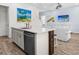 Open-concept kitchen with island seating and living room with comfortable couch and stairs in the background at 3020 Parrot Head Pl, Kissimmee, FL 34747