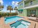 Backyard pool and hot tub is surrounded by lush greenery and palm trees with lounge chairs nearby at 3020 Parrot Head Pl, Kissimmee, FL 34747