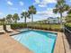Sparkling pool and hot tub surrounded by lush landscaping and tropical palm trees at 3020 Parrot Head Pl, Kissimmee, FL 34747