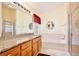 Bathroom with granite countertops, wood cabinets, a soaking tub, and glass shower at 3029 Bransbury Ct, Kissimmee, FL 34747