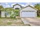 Charming single-story home featuring a white garage door, well-kept lawn, and beautiful flowering shrub in the front yard at 3029 Bransbury Ct, Kissimmee, FL 34747