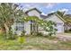 Well-maintained one-story home with lush landscaping, including a beautiful flowering tree, and a white garage door at 3029 Bransbury Ct, Kissimmee, FL 34747