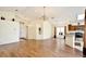 Bright and open living room featuring high ceilings, wood-look flooring, and an adjacent kitchen area with granite countertops at 3029 Bransbury Ct, Kissimmee, FL 34747