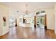 Spacious living room featuring wood-look flooring, a decorative chandelier, and sliding glass doors to a screened in porch at 3029 Bransbury Ct, Kissimmee, FL 34747