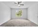 Neutral bedroom featuring modern carpet and a window overlooking the lush outdoors at 30369 Apricot Ave, Eustis, FL 32736