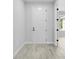 Hallway with wood-look tile flooring, a white door, and views of the home's neutral paint at 30369 Apricot Ave, Eustis, FL 32736