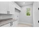 Well-lit laundry room features modern cabinets, granite countertops, and a window for natural light at 30369 Apricot Ave, Eustis, FL 32736