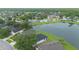 An aerial view showcasing the neighborhood's homes by a serene lake surrounded by lush green landscapes and trees at 3128 Stonehurst Cir, Kissimmee, FL 34741
