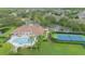 A stunning aerial view showcasing the community pool, clubhouse, and tennis courts surrounded by lush landscaping at 3128 Stonehurst Cir, Kissimmee, FL 34741