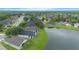 Scenic aerial of neighborhood homes bordering a lake with lush trees and greenery, offering peaceful waterfront living at 3128 Stonehurst Cir, Kissimmee, FL 34741