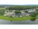 Scenic aerial of neighborhood homes bordering a lake with lush trees and greenery, offering peaceful waterfront living at 3128 Stonehurst Cir, Kissimmee, FL 34741