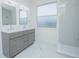 Modern bathroom with double vanity, framed mirrors, and tiled shower at 3128 Stonehurst Cir, Kissimmee, FL 34741