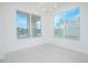 Bright dining room features large windows with pond views, neutral paint and modern light fixture at 3128 Stonehurst Cir, Kissimmee, FL 34741