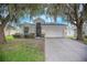 Charming single-story home with a two-car garage and mature trees with Spanish moss in a well-maintained yard at 3128 Stonehurst Cir, Kissimmee, FL 34741