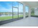 Screened lanai with tiled floor overlooks a serene pond and lush green landscaping at 3128 Stonehurst Cir, Kissimmee, FL 34741
