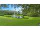 Picturesque pond with a fountain, surrounded by lush greenery, offering a serene and inviting community space at 3128 Stonehurst Cir, Kissimmee, FL 34741