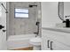 Bright bathroom showcasing a tub with marble-like tile, sleek black fixtures, and a modern vanity at 3397 Janet St, Apopka, FL 32712