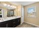 Bathroom featuring a double vanity, large mirror, tiled floors, and a glass-enclosed shower at 3883 Crawley Down Loop, Sanford, FL 32773