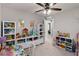 Playful bedroom space featuring white shelving, toys, and a view into the hall at 3883 Crawley Down Loop, Sanford, FL 32773