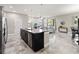 Modern kitchen with gray stone floors, dark cabinets, large island, and an open floor plan into the living room at 3883 Crawley Down Loop, Sanford, FL 32773