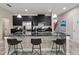 Modern kitchen features black cabinetry, stainless steel appliances, and a large center island with bar stool seating at 3883 Crawley Down Loop, Sanford, FL 32773