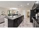 Open kitchen with stainless steel appliances, dark cabinets, and island with seating adjacent to the dining room at 3883 Crawley Down Loop, Sanford, FL 32773