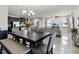 Open-concept living space featuring dining area and kitchen with dark cabinets, leading into a naturally lit living room at 3883 Crawley Down Loop, Sanford, FL 32773