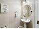 Bright powder room featuring a pedestal sink, oval mirror, and stylish decor at 3883 Crawley Down Loop, Sanford, FL 32773