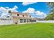 Expansive backyard featuring lush green grass and a charming two-story home with screened lanai at 4221 Kezar Ct, Belle Isle, FL 32812