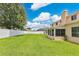 Large grassy backyard with a white fence and rear exterior view of the home at 4221 Kezar Ct, Belle Isle, FL 32812