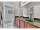 Bathroom featuring double sinks, wooden cabinets, and a view of greenery from the window at 4221 Kezar Ct, Belle Isle, FL 32812