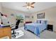 Bright bedroom with a ceiling fan, a blue bedspread, and a functional study desk at 4221 Kezar Ct, Belle Isle, FL 32812