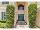 Inviting front entrance with double doors, flanked by symmetrical greenery and adorned with wreaths, creating a welcoming ambiance at 4221 Kezar Ct, Belle Isle, FL 32812